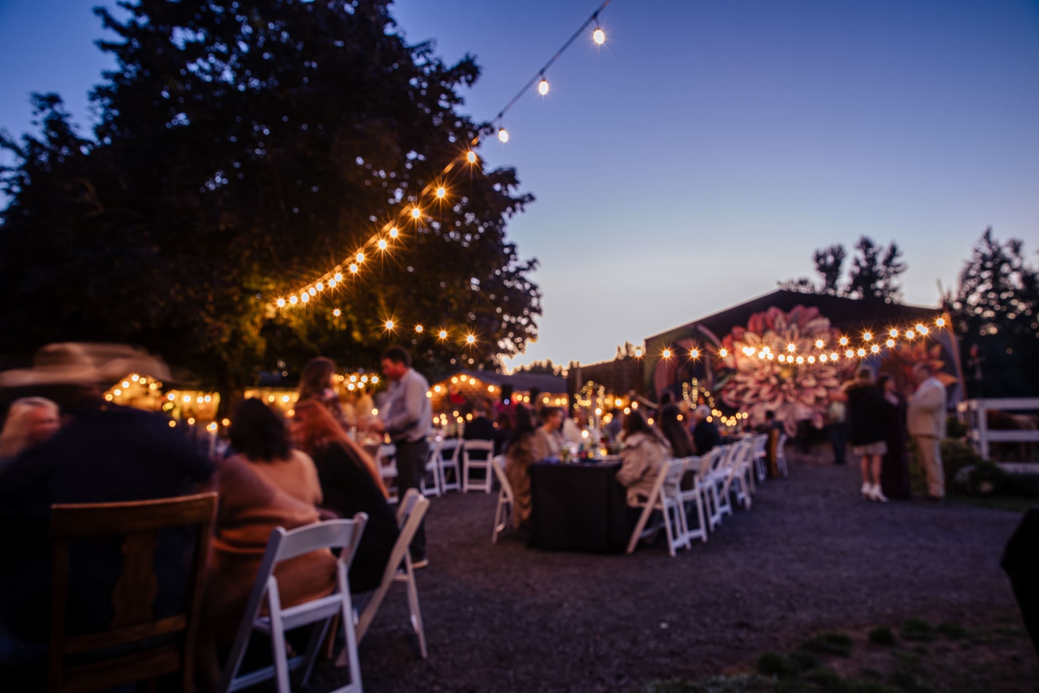 Outdoor evening event with string lights.