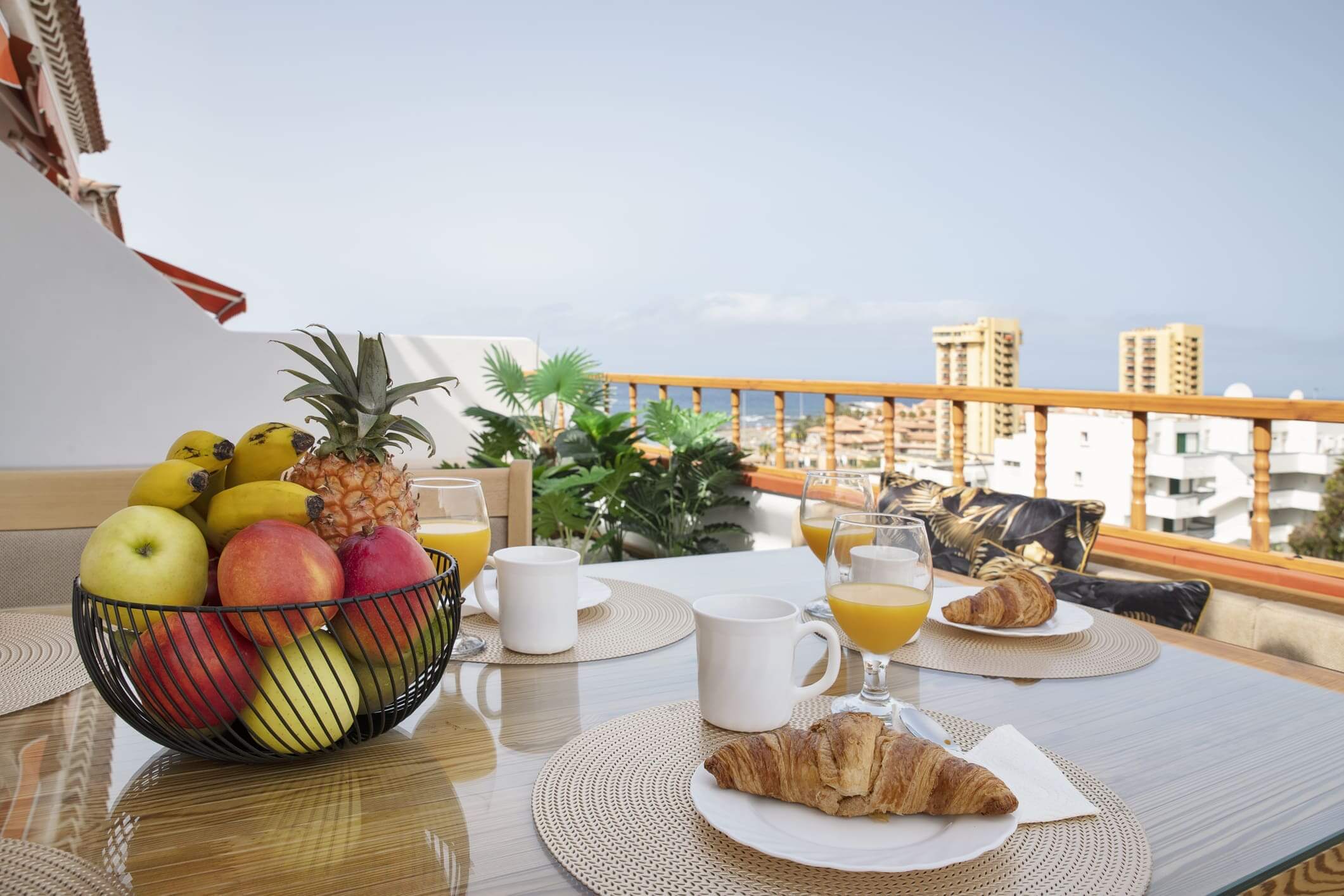 Rooftop breakfast with fruit and pastries.