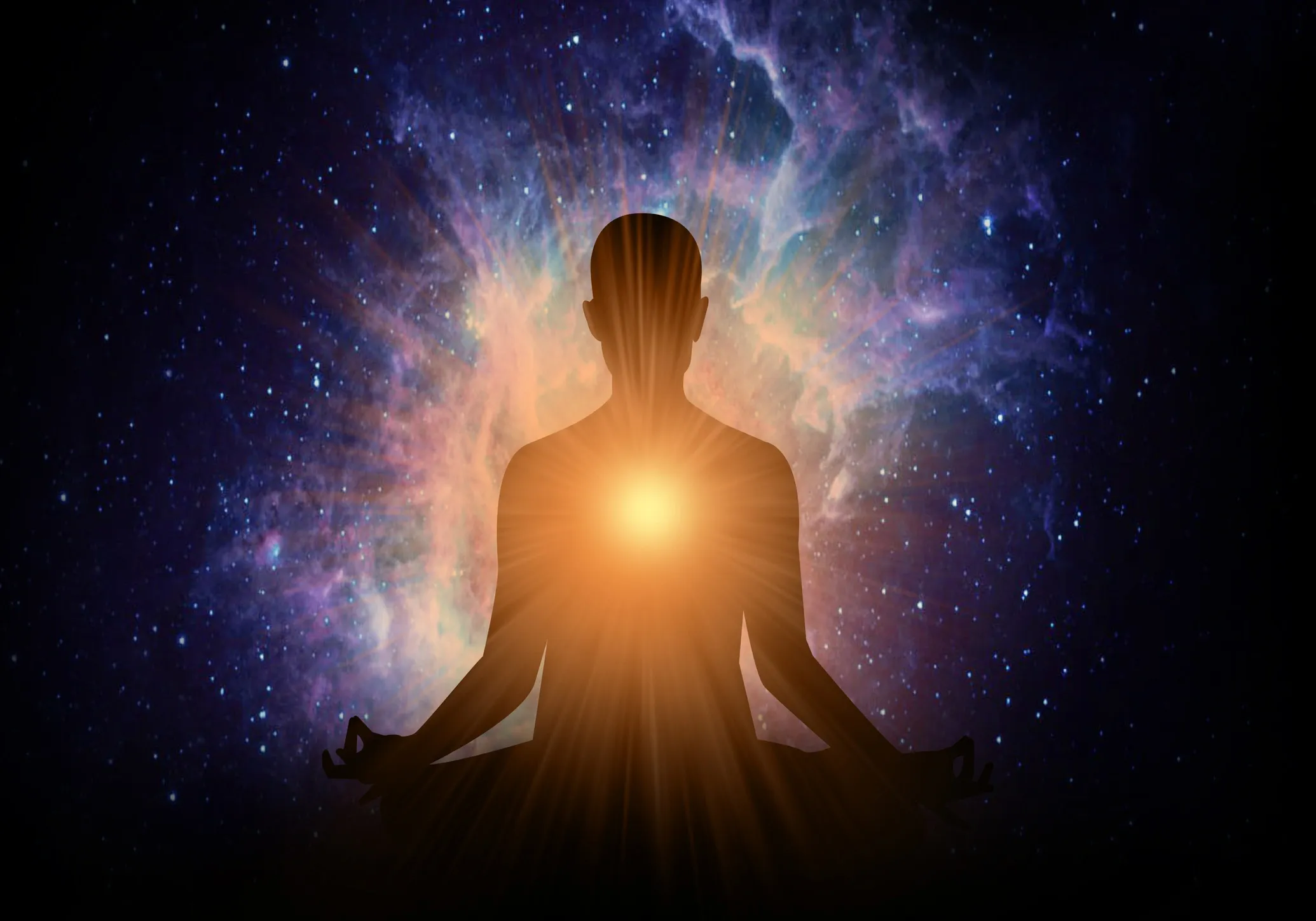 Silhouette meditating with glowing heart against cosmic background.